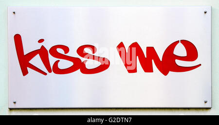 Placca in acciaio che dice 'kiss me' in rosso. Foto Stock