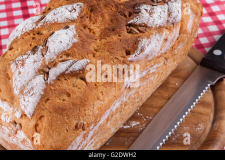 Pane fatto in casa closeup sul piatto di legno con il coltello di taglio Foto Stock