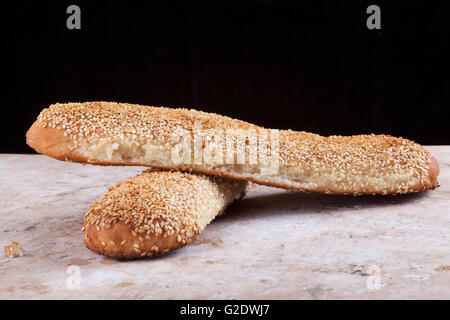 Ciambelle di sesamo su sporco usato piastra di legno Foto Stock