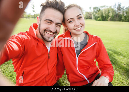 Sport l uomo e la donna che fa selfies in posizione di parcheggio Foto Stock