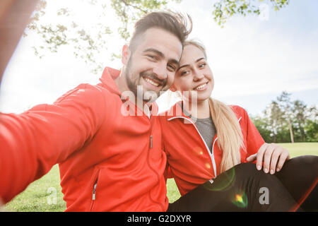 Sport l uomo e la donna che fa selfies in posizione di parcheggio Foto Stock