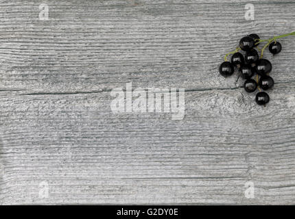 Ribes nero in primo piano su un anziano tavola di legno, Plank. Texture, pattern nella scheda. Foto Stock