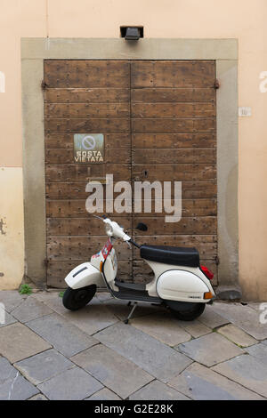 Classic scooter Vespa parcheggiata in un vicolo di Toscana - Arezzo, Italia Foto Stock