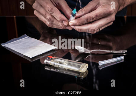Preparazione di farmaci in una siringa su sfondo scuro con la riflessione Foto Stock