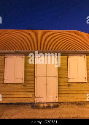 Old st bart home con stagno ondulato tetto, scheda di clap schierandosi con persiane e porte e finestre Foto Stock