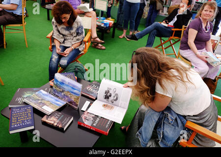 Festival di fieno, Wales, Regno Unito - Maggio 2016 - Ai visitatori del Festival di fieno prendere la possibilità di sedersi e sfogliare una selezione di nuovi libri in offerta al Festival bookshop. Foto Stock