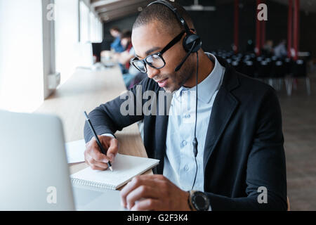 Bel giovane imprenditore creativo rendendo note in Office Foto Stock