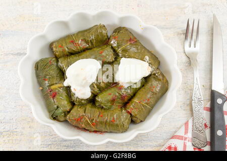 Sarma rotoli in una piastra ricoperta di spezie e di panna acida Foto Stock