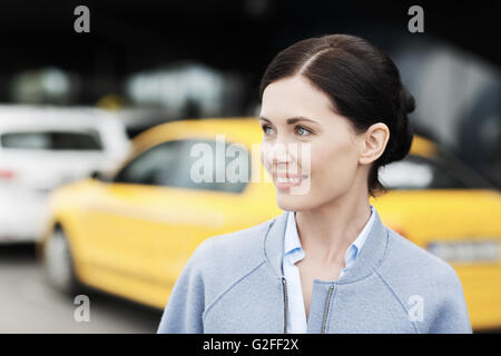 Donna sorridente oltre la stazione dei taxi o strada di città Foto Stock