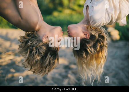 Ragazzo e ragazza appeso a testa in giù attorno al bacio Foto Stock