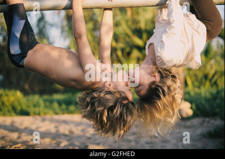 Ragazzo e ragazza appesi capovolti Kissing Foto Stock