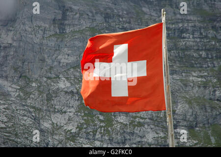 Bandiera svizzera svolazzanti sul vento in alta montagna vicino a Grindelwald nelle Alpi della Svizzera. Foto Stock