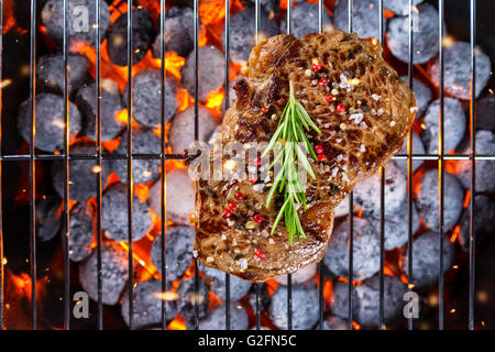Bistecca di manzo alla griglia nel fuoco, scattato dalla vista di cui sopra Foto Stock