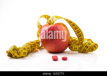 Apple rosso giallo con nastro di misurazione e le pillole di rosso con la riflessione isolata su sfondo bianco Foto Stock