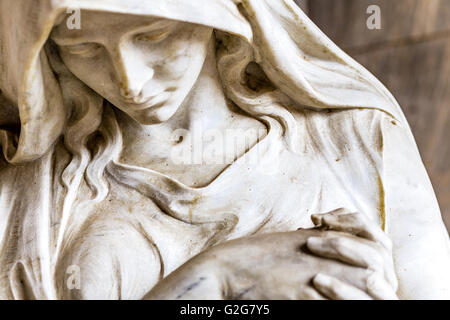 La faccia della statua di dolore di donna con le mani giunte in preghiera Foto Stock