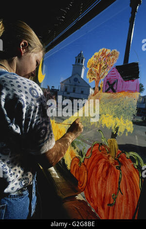 Ragazza pittura una decorazione halloween su una finestra. Foto Stock