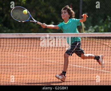 Ragazzo, 10, giocare a tennis e a colpire un colpo al volo di diritto, Monaco di Baviera, Baviera, Baviera, Germania Foto Stock