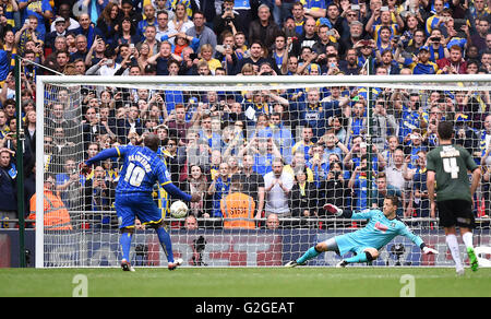 AFC Wimbledon's Adebayo Akinfenwa punteggi al suo fianco il secondo obiettivo del gioco dalla pena spot durante la puntata Sky League Play-Off due match finale allo stadio di Wembley, Londra. Foto Stock