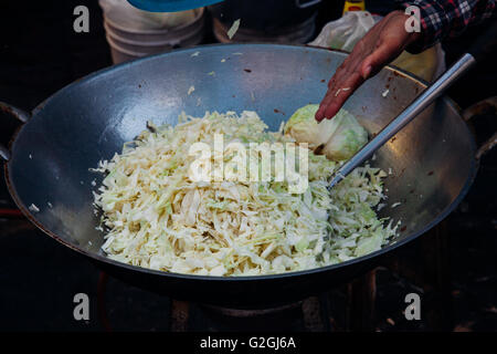 Cavolo nel wok sulla strada di Bangkok, Tailandia. Foto Stock
