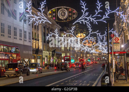 Luci di Natale lungo una trafficata via Regent affollata di acquirenti nel periodo natalizio nel West End di Londra Foto Stock