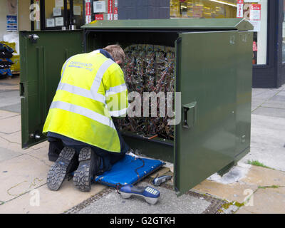 Un BT Openreach telecomunicazioni tecnico che lavora su un cabinet in un centro città Foto Stock