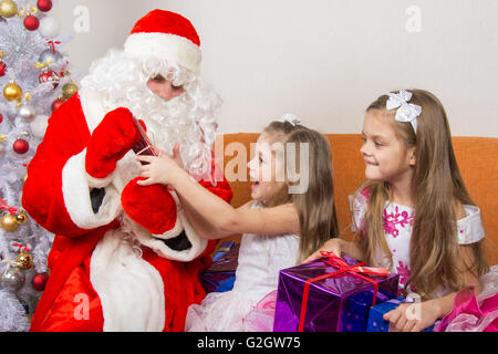 Il Babbo Natale dà presenta due sorelle Foto Stock