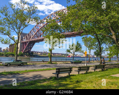 Classic Cars parcheggiata in un parco con il fiume e il ponte di overhead Foto Stock