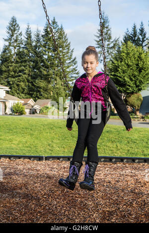 Ragazza di 10 anni su un altalena in un parco giochi in Issaquah, Washington, Stati Uniti d'America Foto Stock