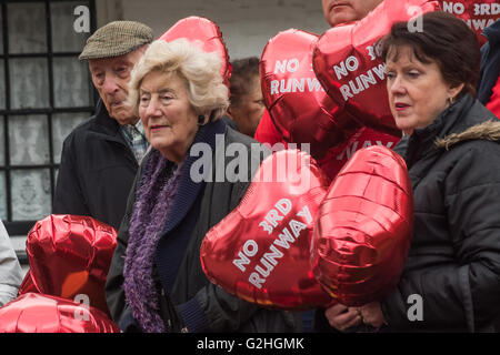 Harmondsworth, Londra, Regno Unito. Il 30 maggio 2016 HACAN e anti-3rd i sostenitori della pista a Harmondsworth 'celebrare' Heathrow il settantesimo compleanno con 70 'nessuna terza pista' palloncini e oltre 750 aerei nero sul villaggio verde, che rappresenta il numero di case che verrebbero distrutte. Residenti LOocal tenere alcuni dei 70 'nessuna terza pista' balloonsas essi ascoltare discorsi e canzoni che hanno fatto cancellare gli effetti disastrosi a livello locale e in gran parte del sud-est di qualsiasi nuova pista. Credito: Peter Marshall / Alamy Live News Foto Stock