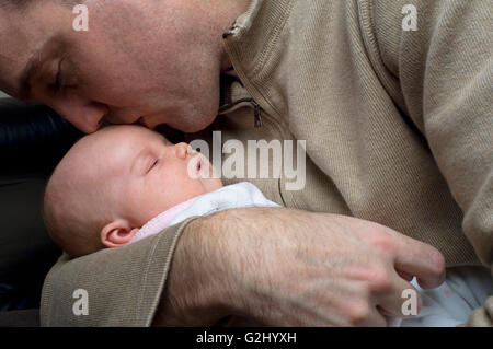 Padre baciare neonato sulla fronte Foto Stock