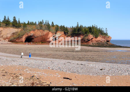 Persone non identificate godendo la spiaggia rocciosa e grotte a bassa marea in St. Martins, New Brunswick, nelle province marittime di Foto Stock