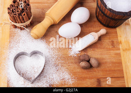 La cottura Ingredienti un utensili in legno marrone tagliere Foto Stock