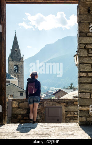 Giovane donna adulta guardando alla vista panoramica dal villaggio, vista posteriore, Lanslevillard, Val Cenis Vanoise, Francia Foto Stock