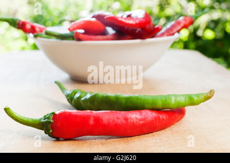 Due chili peppers in primo piano e una prua con peperoncino in background Foto Stock