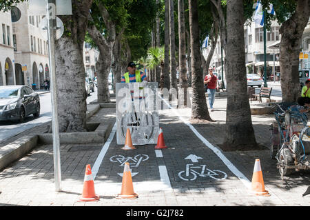 Lavoratori municipali contrassegnare una pista ciclabile. Fotografato a Jaffa, Israele Foto Stock