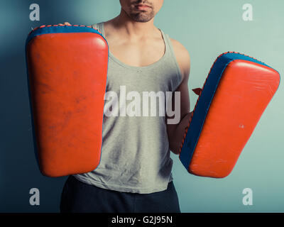 Una preparazione atletica giovane uomo è in possesso di pastiglie e è pronto per alcuni muay thai o mixed martial arts e formazione Foto Stock