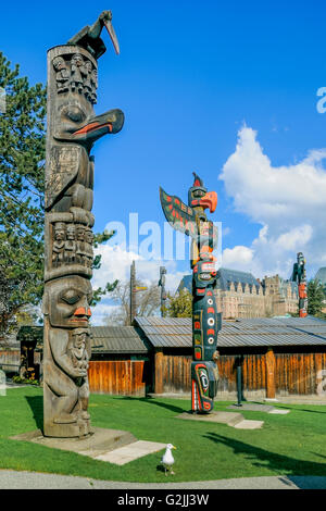 Prima Nazione Totem, Thunderbird Park, accanto al Royal British Columbia Museum, con Empress Hotel in background, Victoria, B Foto Stock