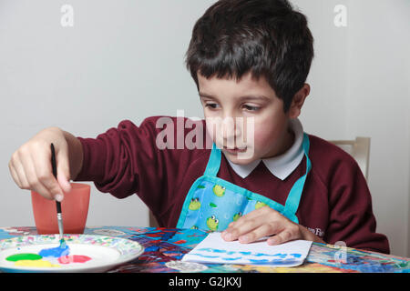 Classe d'arte nella scuola primaria-schoolboy dipingere un quadro Foto Stock