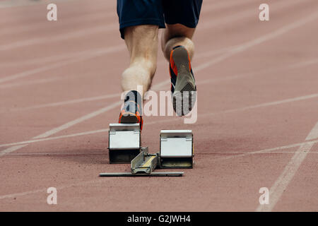 Inizio della sprint atleta uomini. vista posteriore solo le gambe Foto Stock