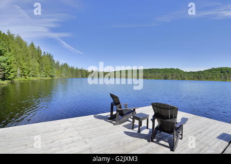 Dock e sedie di Muskoka sul lago Muskoka, Ontario Foto Stock