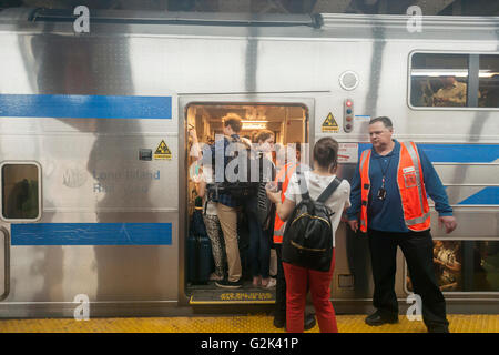 Migliaia pack la palla di cannone alla Stazione Penn di New York di uscire dalla città per il weekend del Memorial Day Venerdì 27 Maggio, 2016. Ogni venerdì durante il periodo estivo il treno, consistente di double-decker cars tirato da un potente dual-mode locomotiva, correrà express per Westhampton sull'Isola Lunga rendendo le 76 miglia di viaggio in 94 minuti. Da Westhampton continuerà a punti a est che arrivano in corrispondenza della punta dell'isola, Montauk. La domenica il treno procederà in retromarcia e tornare alla stazione di Penn. Il treno è il solo nome eseguito su ferrovia. Il viaggio da Penn Station a Montauk terminale è 117 Foto Stock
