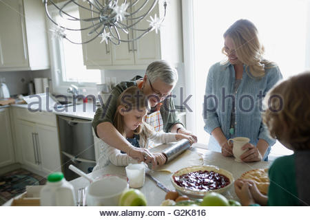 Multi-generazione famiglia ciliegia di cottura la torta in cucina