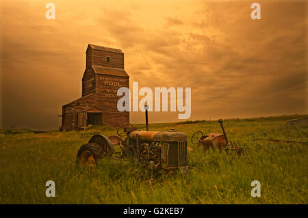 Elevatori della granella e i vecchi trattori in città fantasma Bents Saskatchewan Canada Foto Stock