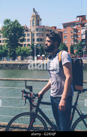 Spagna, Bilbao, uomo con ciclo di corse sul fiume Foto Stock