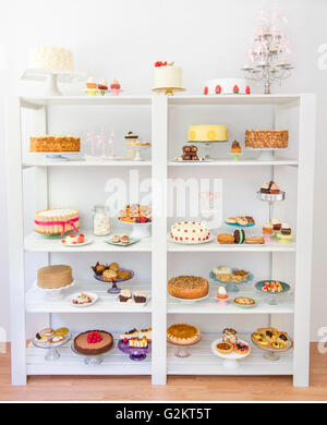 I dessert assortiti su scaffali bianchi Foto Stock