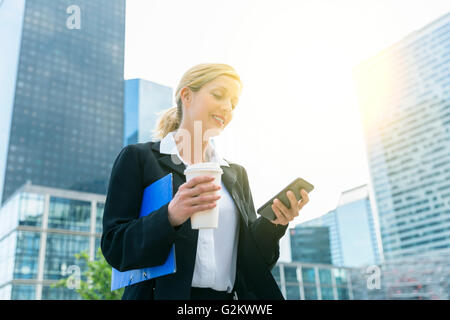 Imprenditrice di messaggistica di testo nel quartiere finanziario Foto Stock