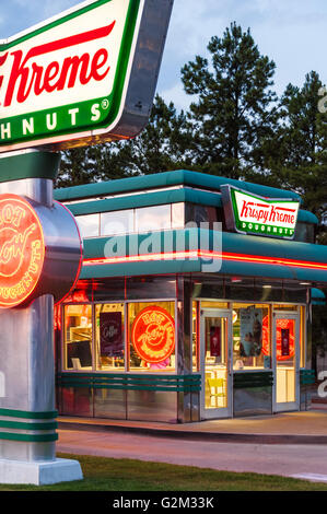 Negozio di ciambelle Krispy Kreme con cartello illuminato al neon "Hot Now" che indica la disponibilità di ciambelle calde e fresche. (STATI UNITI) Foto Stock