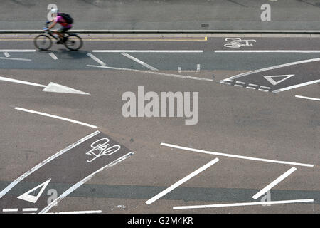 Ciclista utilizzando piste ciclabili su strada. Foto Stock