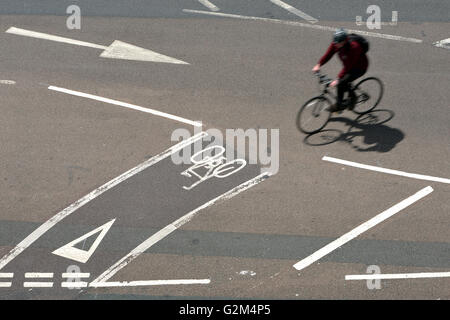 Ciclista utilizzando piste ciclabili su strada. Foto Stock