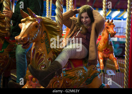 Modello rilasciato immagine di una giovane ragazza a cavallo su un merry-go-round a Southsea, Portsmouth, Hampshire, Regno Unito Foto Stock